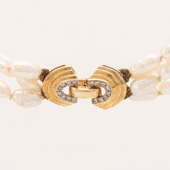 A necklace of cultured pearls set with a 14K gold lock and round brilliant cut diamonds.