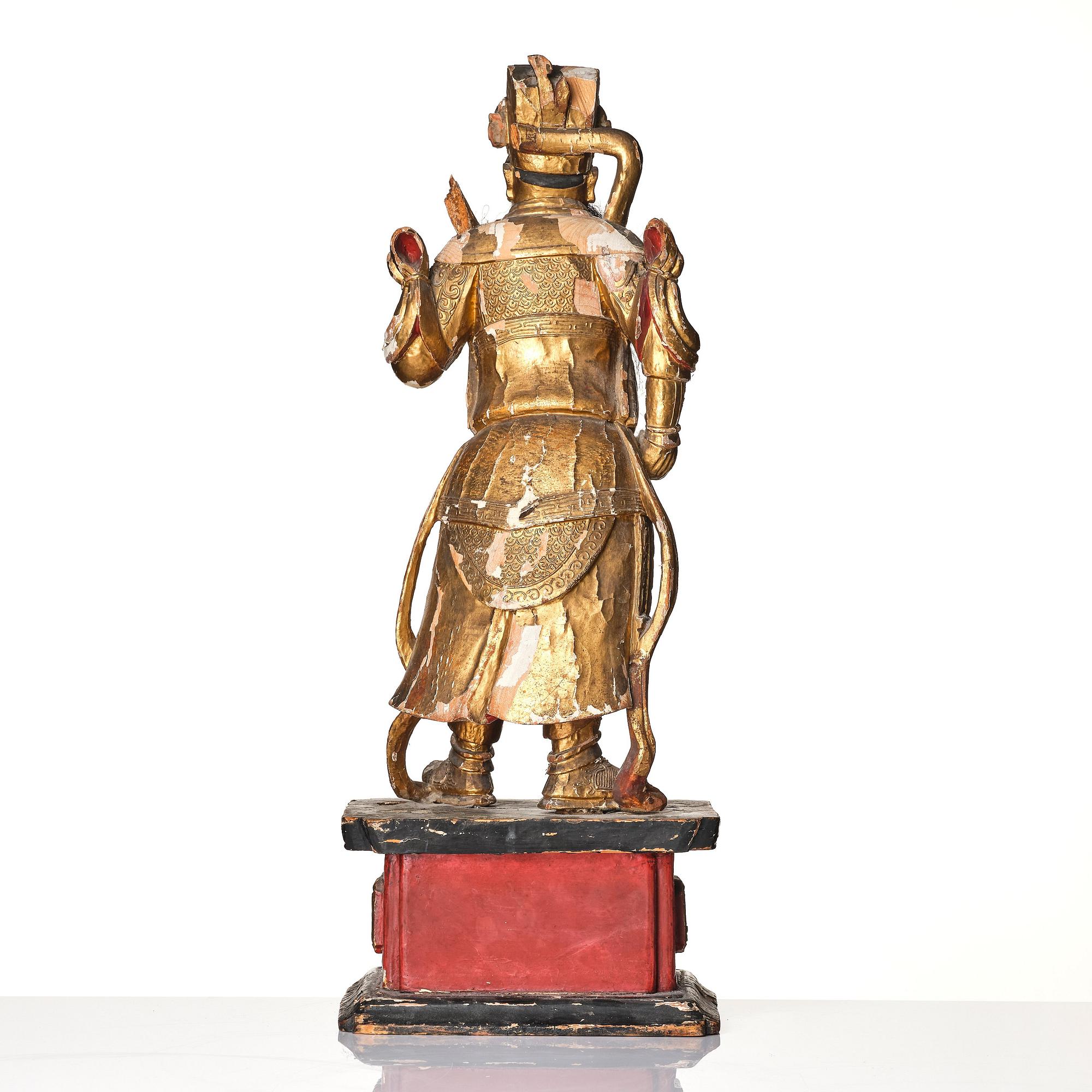 A gilt and lacquered standing figure of a guardsman, Qing dynasty.