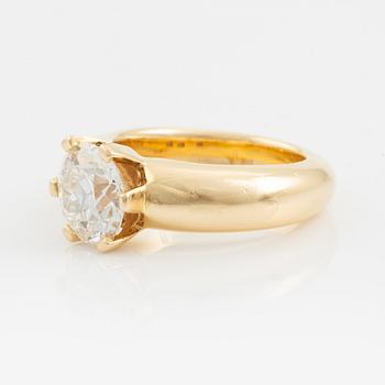 An 18K gold ring set with a round brilliant-cut diamond.