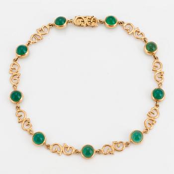 An 18K gold Ateljé Stigbert bracelet with cabochon-cut green stones.