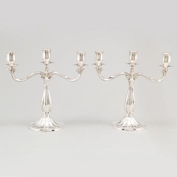 A pair of Swedish silver candelabra, makers mark GAB, Stockholm 1935 and 1938.