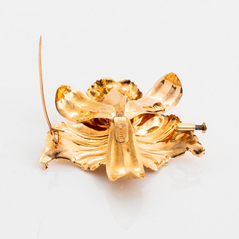 Brosch 18K guld med en rund briljantslipad diamant och fasettslipade smaragder.