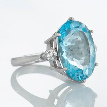 An 18K white gold ring set with a faceted topaz and two pear shaped brilliant-cut diamonds.