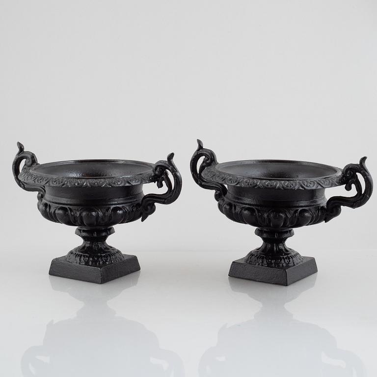 A pair of cast iron garden urns, 20th century.