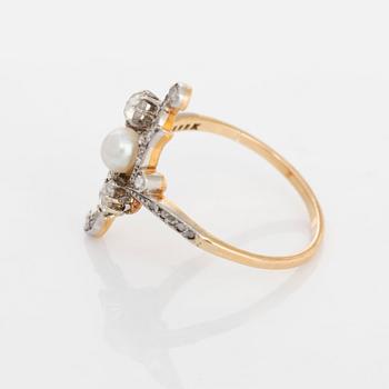 A platinum and gold ring set with a pearl and rose-cut diamonds.