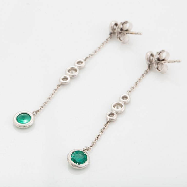 A pair of 18K white gold earrings set with faceted emeralds.