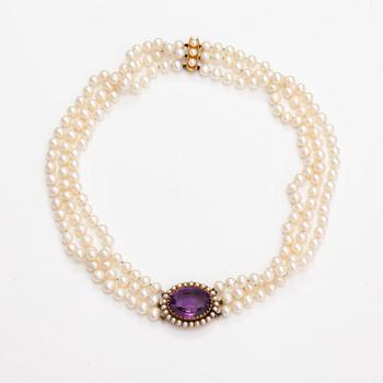 A three-strand cultured pearl collier with an amethyst and 14K gold.