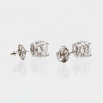 A pair of 14K white gold earrings set with round brilliant-cut diamonds.