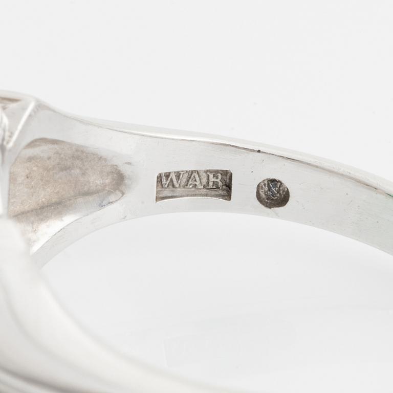 An 18K white gold ring set with a cabochon-cut emerald and eight-cut diamonds.