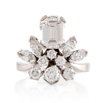 562. A white gold emerald cut diamond, navette- and round brilliant cut diamonds ring.