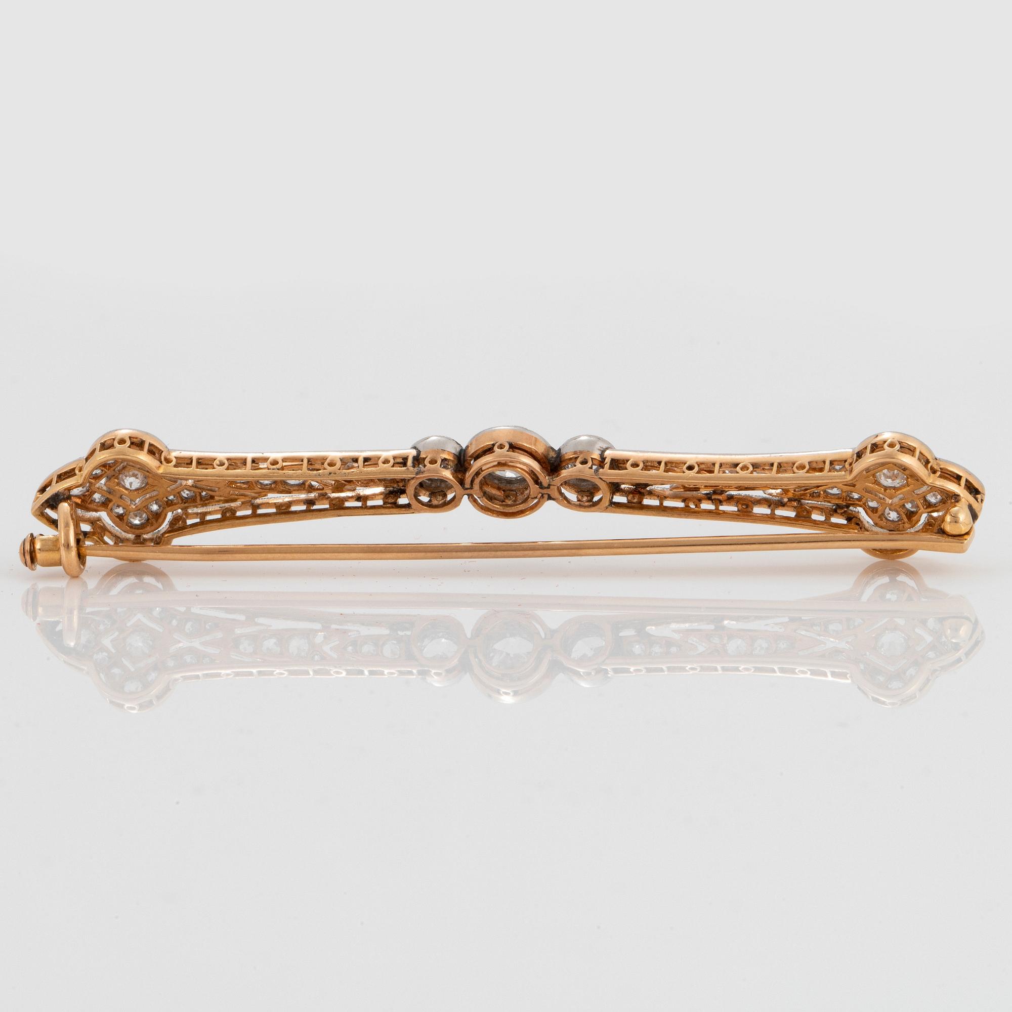 A platinum and 18K gold brooch set with old-cut diamonds with a total weight of ca 1.25 cts.