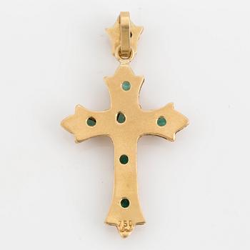 An 18K gold and emrald cross pendant.