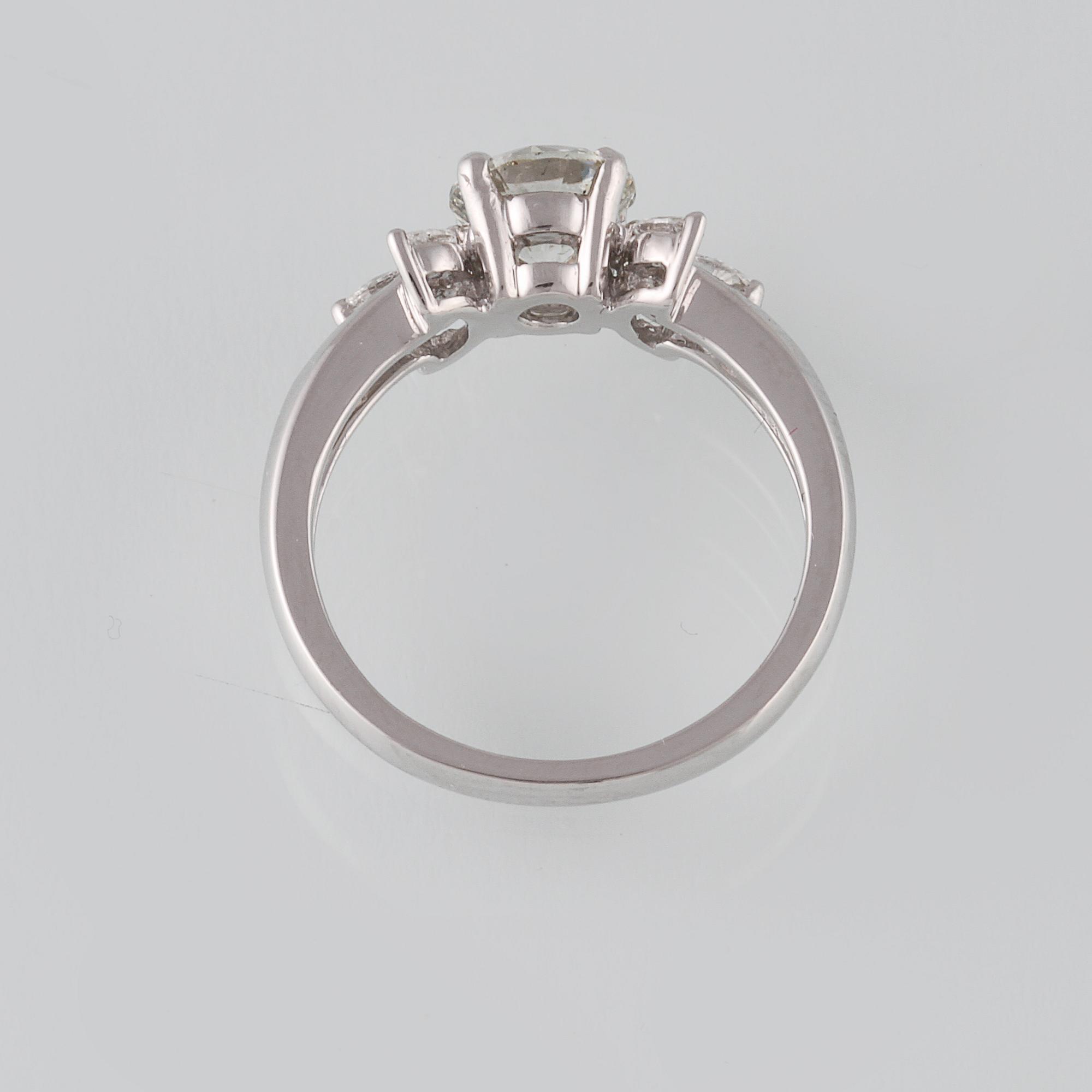 RING, 18K vitguld med briljantslipad diamant ca 1.11 ct samt 6 navetteslipade diamanter 0.26 ct. Vikt 4,2 gram.