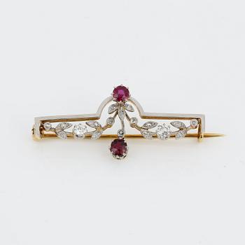 BROSCH, 18K guld med runda fasetterade rubiner, tot ca 0,40 ct och små rosen och gammalslipade diamanter. Vikt ca4,48 g.