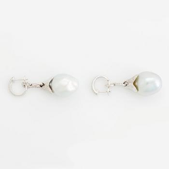 A pair of 18K white gold earrings set with cultured South Sea pearls and round brilliant-cut diamonds.