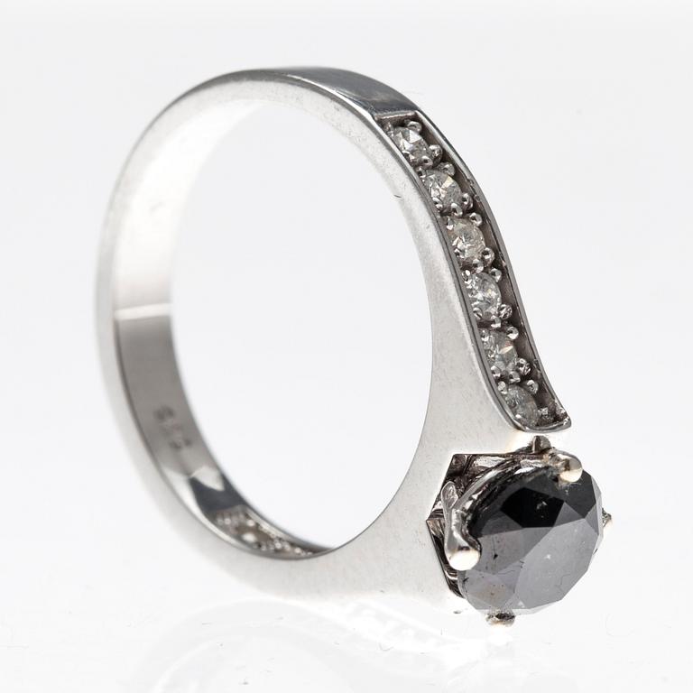 RING, 14K vitguld med en svart samt 12 briljantslipad diamanter ca1,09 ct resp tot ca 0,24ct. Tot vikt 3,5 g.