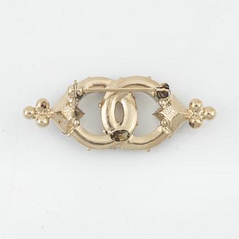 Chanel, a metal and rhinestone brooch, 2015.