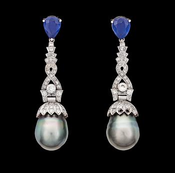 1057. A pair of cultured Tahiti pearl, blue sapphire and diamond earrings, tot. app. 2.40 cts.