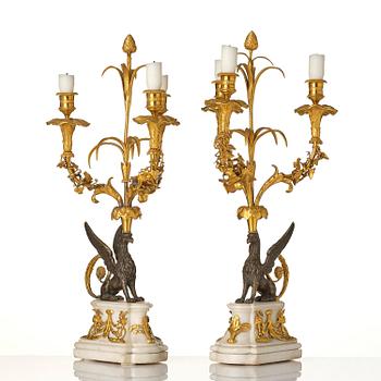 A pair of three-light Louis XVI patinated and ormolu candelabra in the manner of François Rémond, late 18th century.