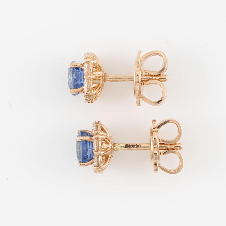 A pair of 14K gold earrings with faceted sapphires and round brilliant-cut diamonds.