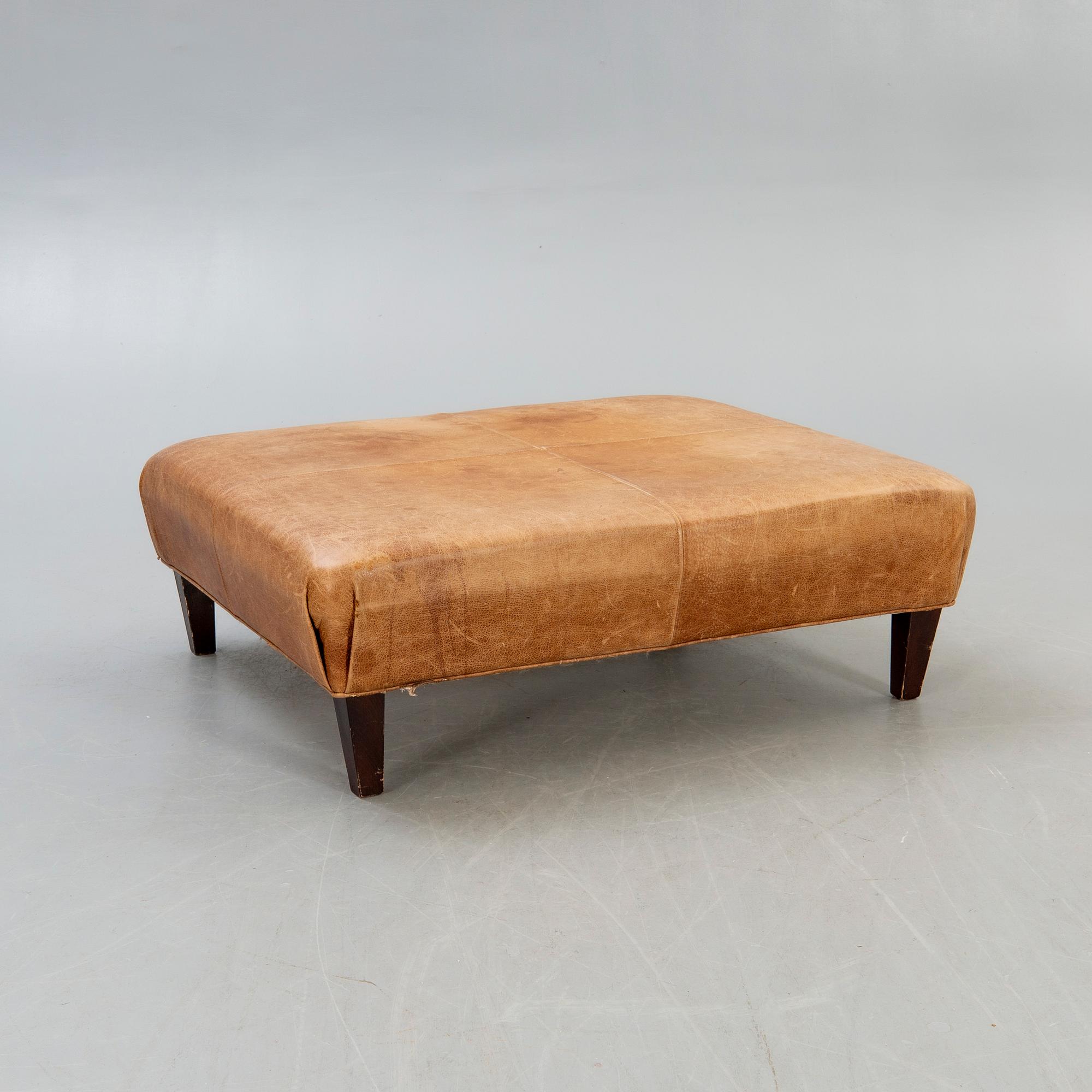 A leather ottoman/coffee table alter part of the 20th century.