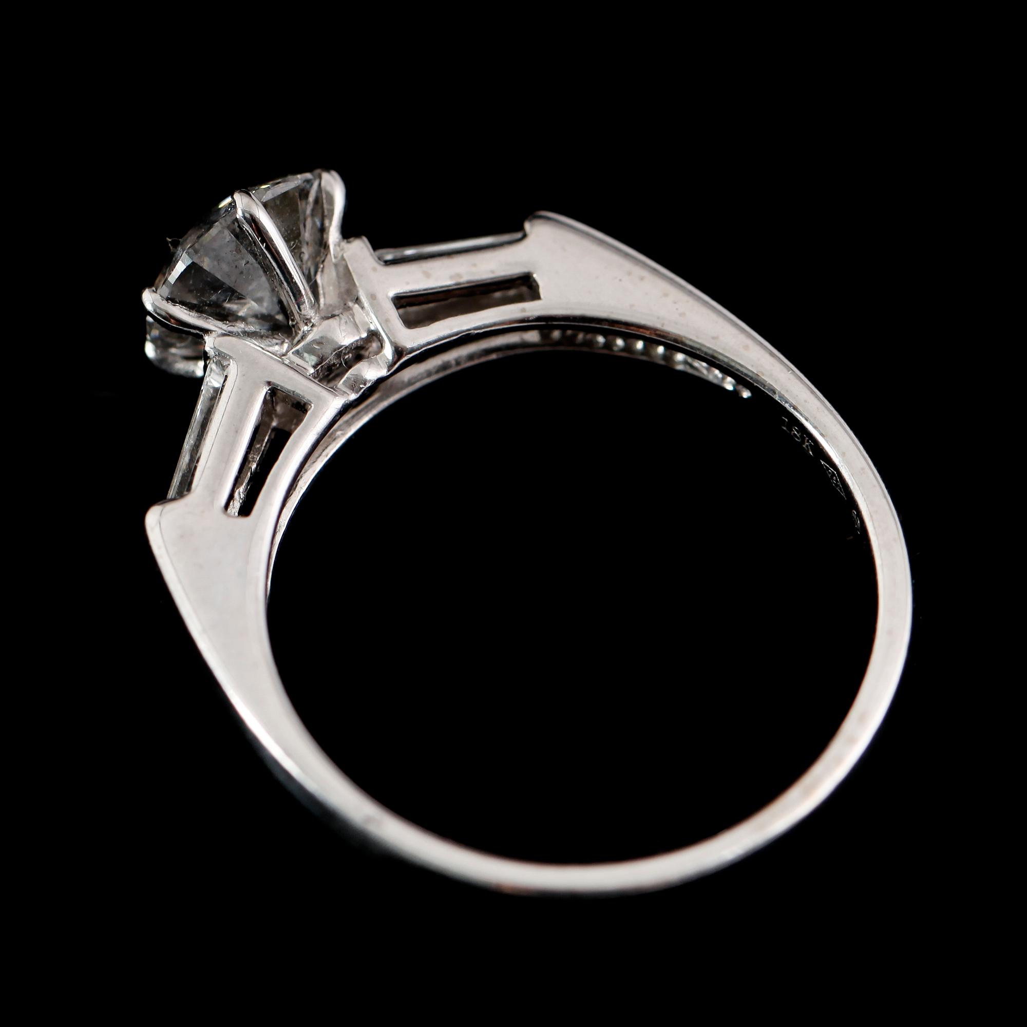 RING, 18 k vitguld, med briljantslipad diamant 1.31 ct och 2 baguetteslipade diamanter.