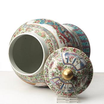 A Canton famille rose jar with cover on a tall wooden stand, Qing dynasty, late 19th Century.
