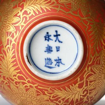 A group of 13 red and gold decorated blue and white bowls with dragon and crane motif, Meiji period (1868-1912).