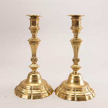A pair of rococo brass candlesticks, possibly France.