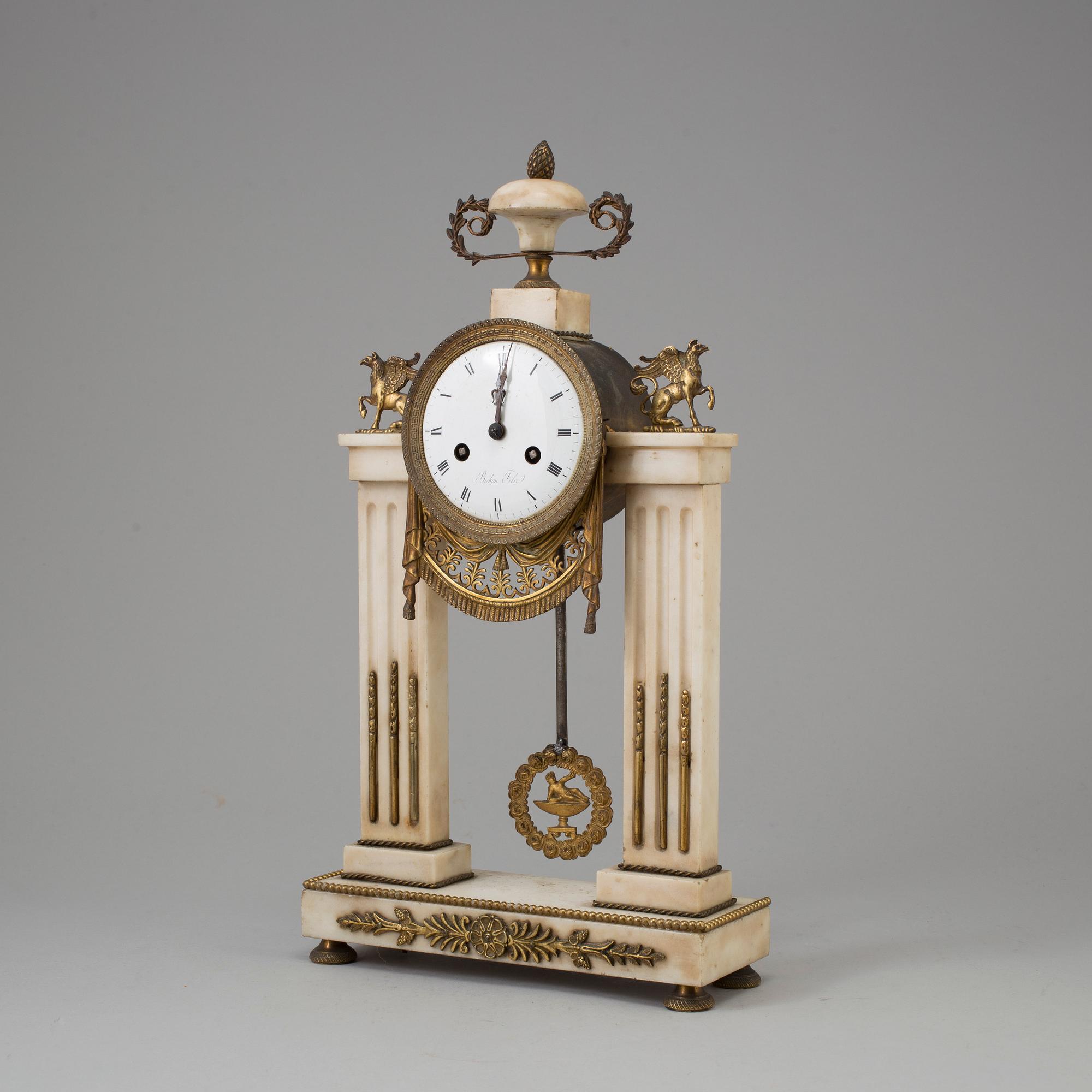 A FRENCH EMPIRE MARBLE AND BRASS MANTEL CLOCK, first half of the 19th century.