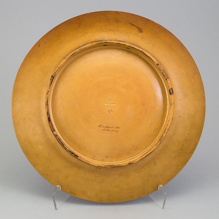 A wall plate by Adolf Neumann, Rörstrand, signed on verso 1884.