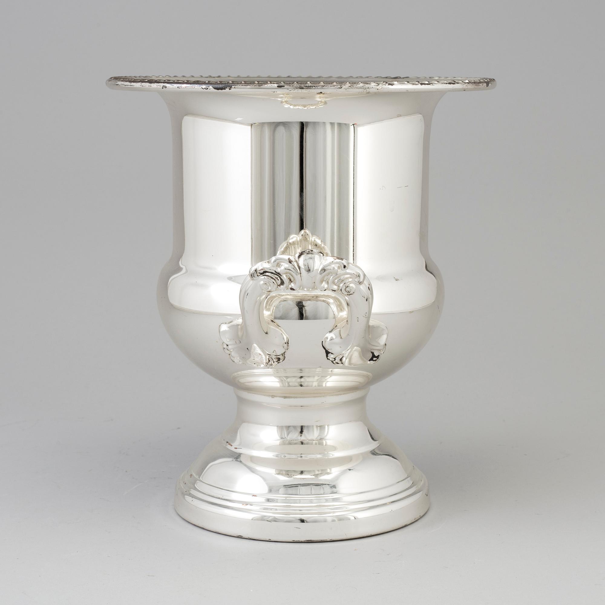 A 20TH CENTURY SILVERVED METAL CHAMPAGNE COOLER.