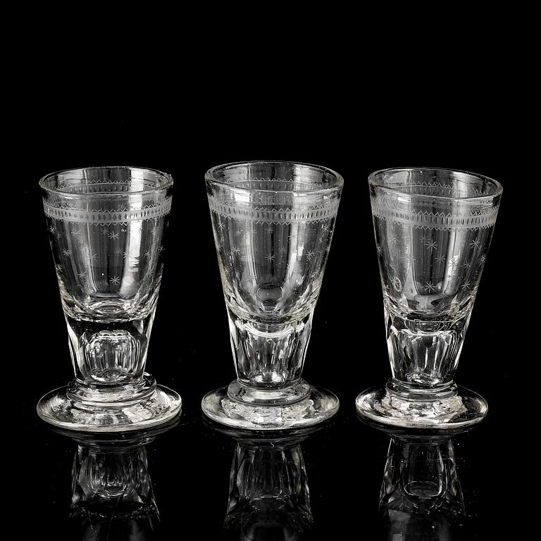 A glass bottle and three vodka glasses, 19th Century.