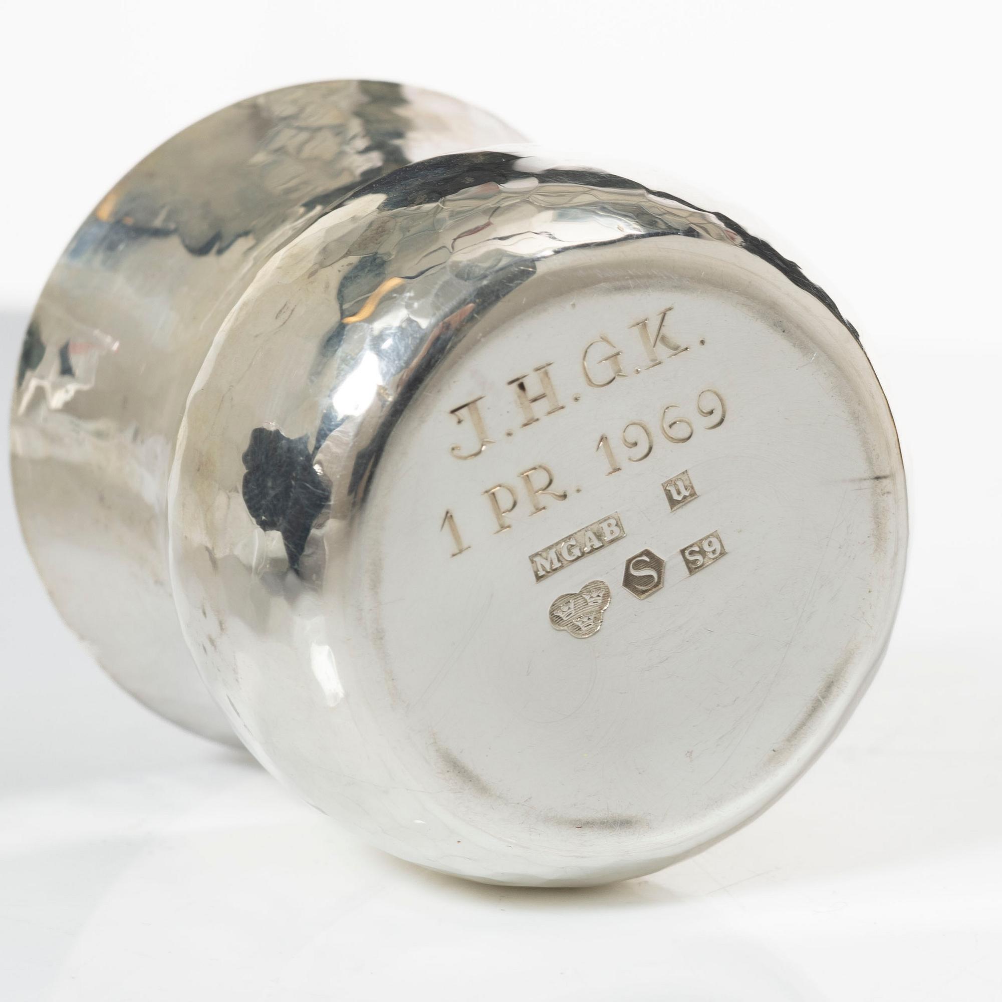 A pair of beakers, two napkin rings, and 17 pieces of cutlery, silver.