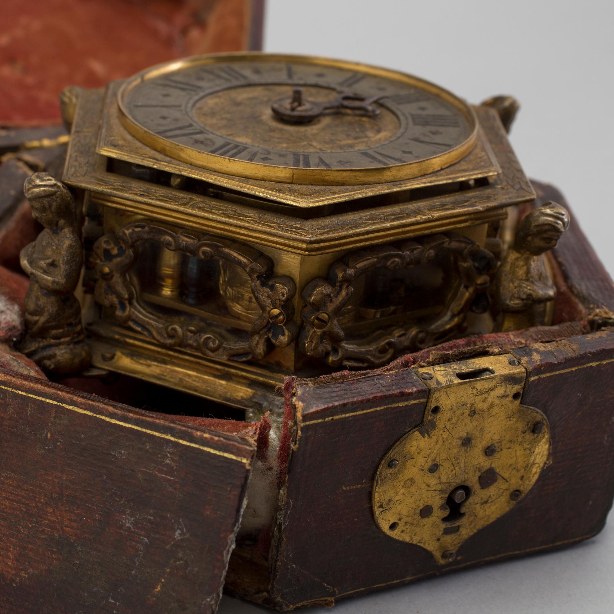 A gilded brass baroque travel clock from around 1700, with original case.