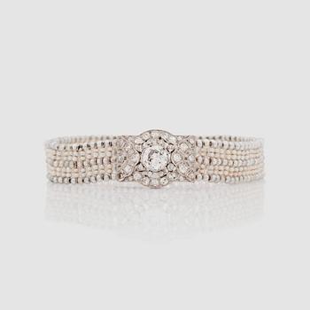 1114. ARMBAND med gammalslipad diamant ca 0.90 ct, orientaliska pärlor samt mindre diamanter, totalt ca 1.00 ct. Ca. 1920-tal.