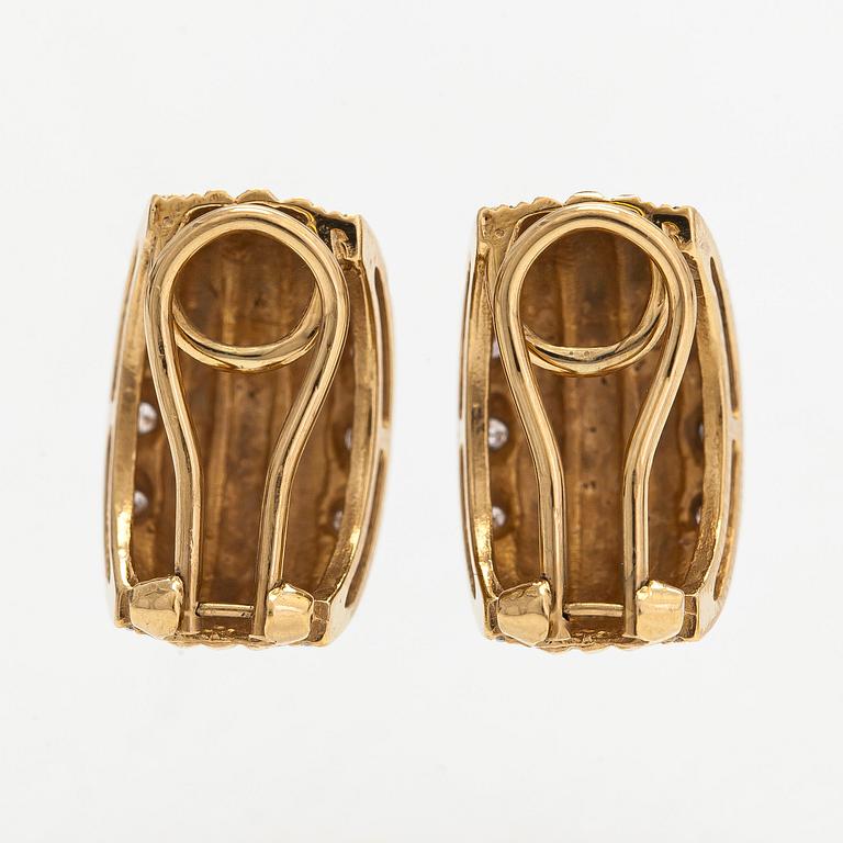 A pair of 18K gold earrings set with small diamonds.