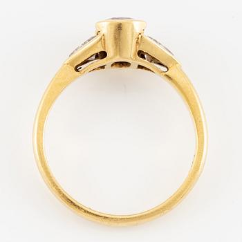 Ring 18K guld med en fasettslipad rubin samt två triangelformade briljantslipade diamanter.
