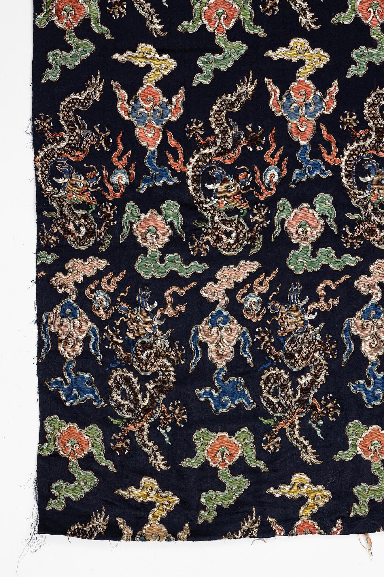 A set of three bolts of silk with 'five clawed dragons' against a midnight blue ground, Qing dynasty, 19th century.