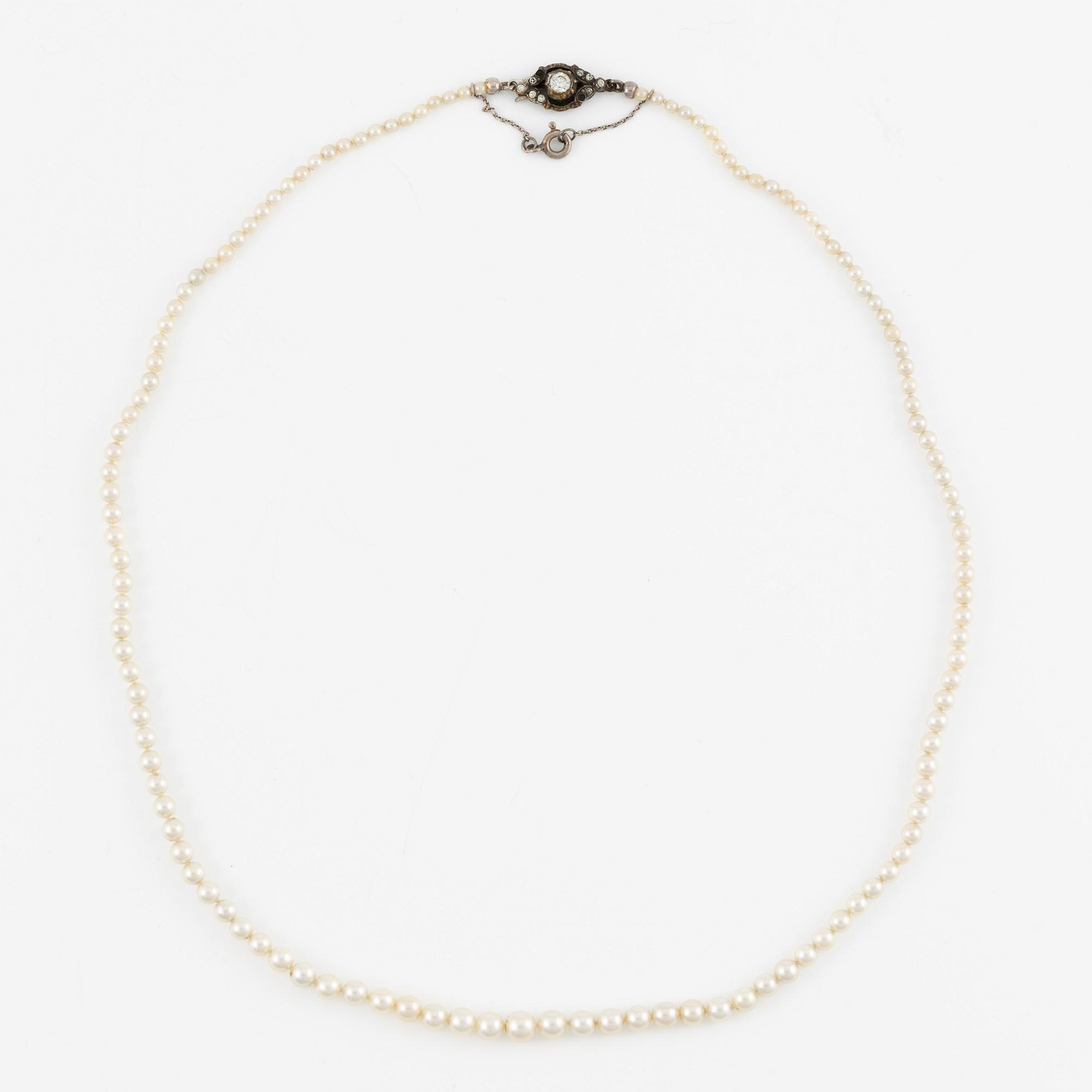 Pearl necklace with graduated cultured pearls, clasp in silver set with pastes, and a pair of pearl earrings,.