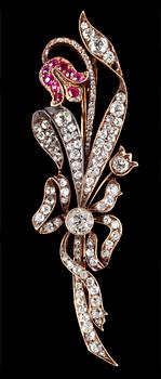 1030. BROSCH, gammal- och rosenslipade diamanter och rubiner, i form av lilja. 1890-tal.