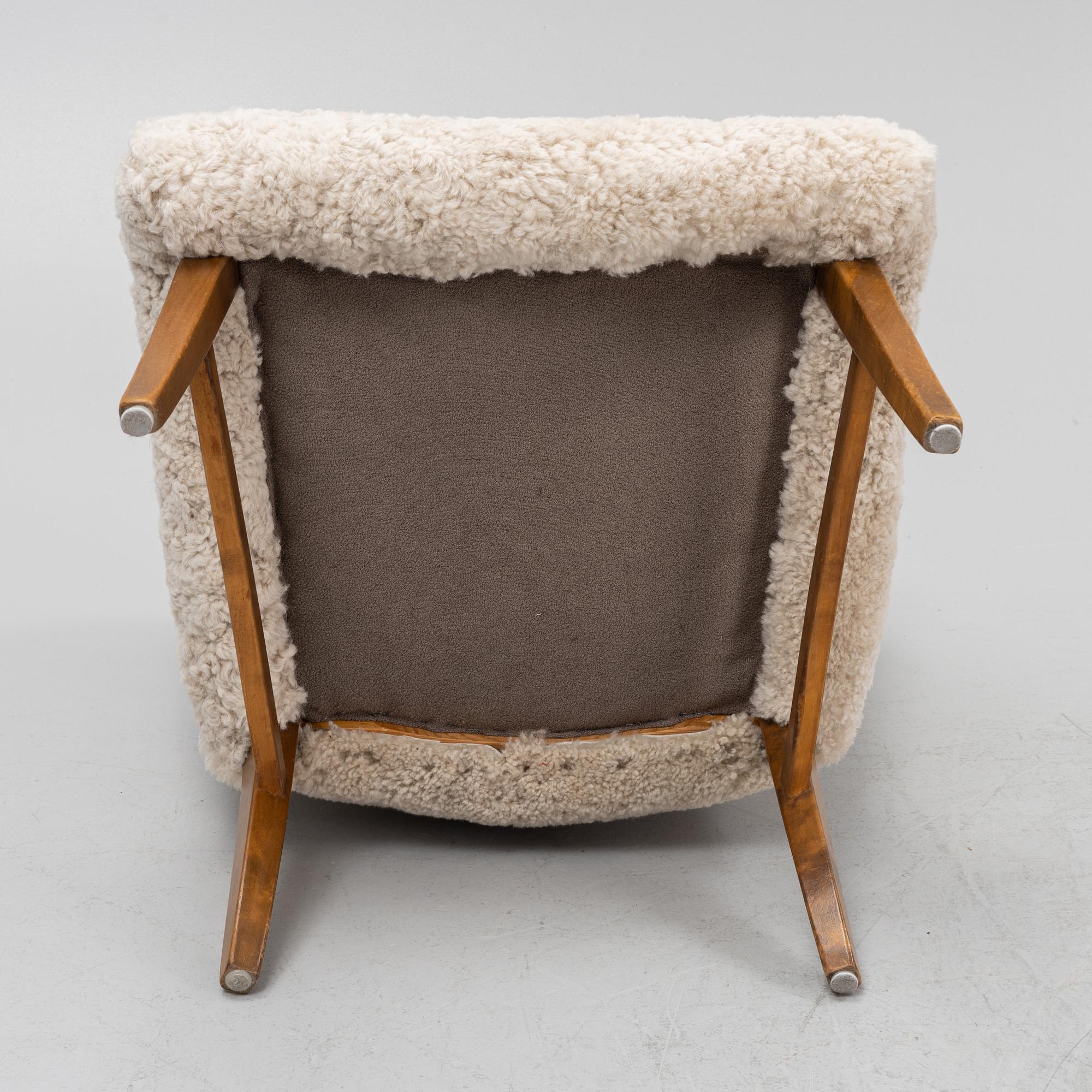 A mid 20th Century easy chair with sheepskin upholstery.