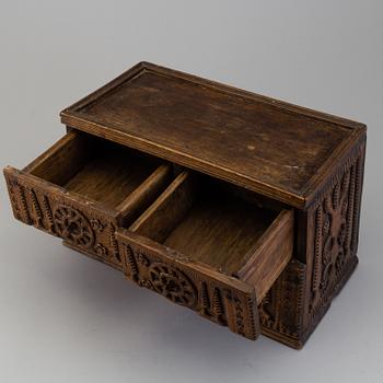 A 19th century wooden box with drawers.