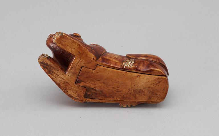 A 19th-20th century birch snuffbox in the shape of a lying dog.
