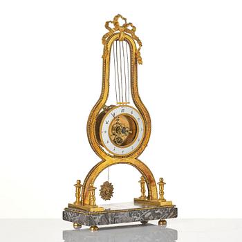 A French Louis XVI ormolu and marble lyre-shaped mantel clock, late 18th century.