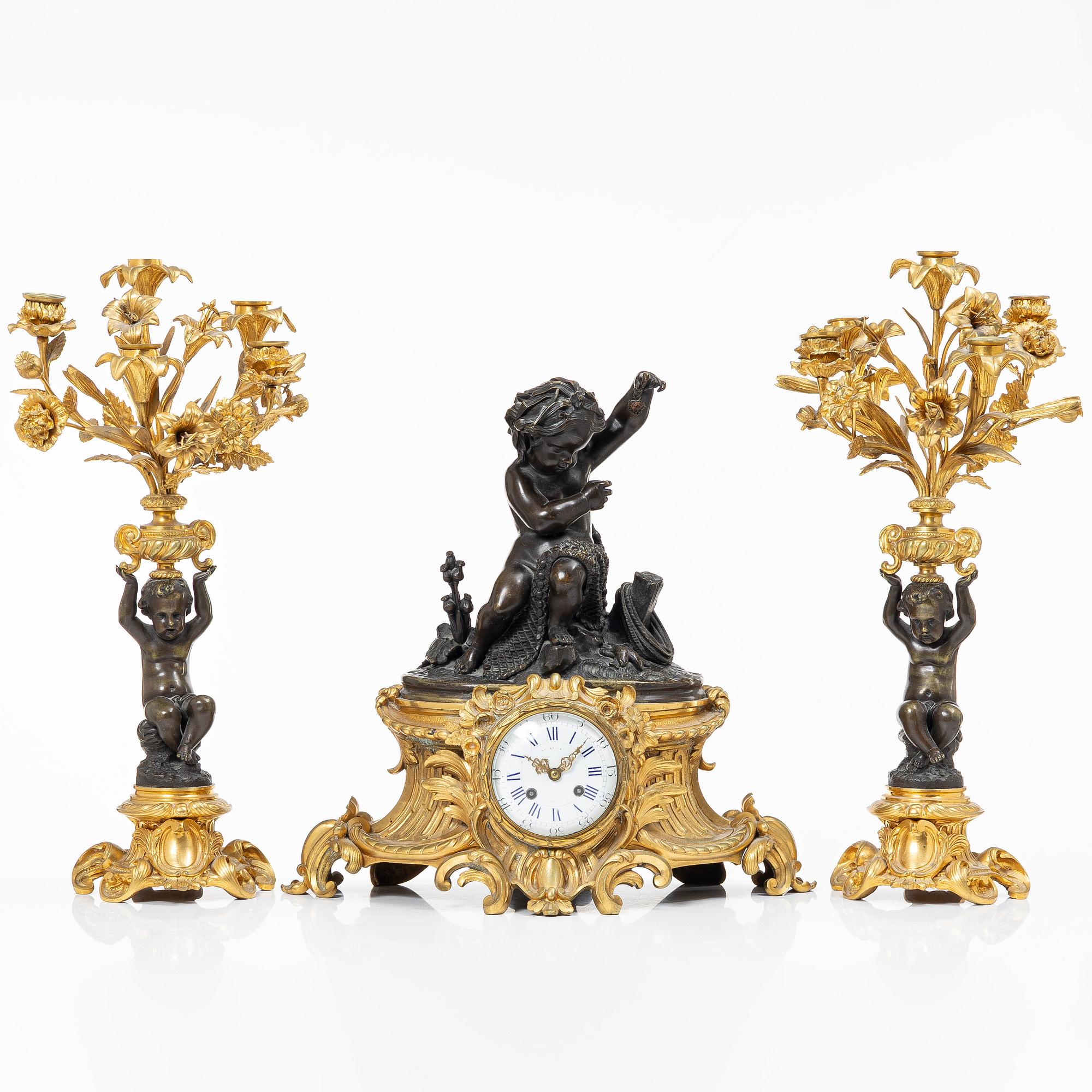 A Rococo style mantle clock and pair of candelabra, France, late 19th Century.