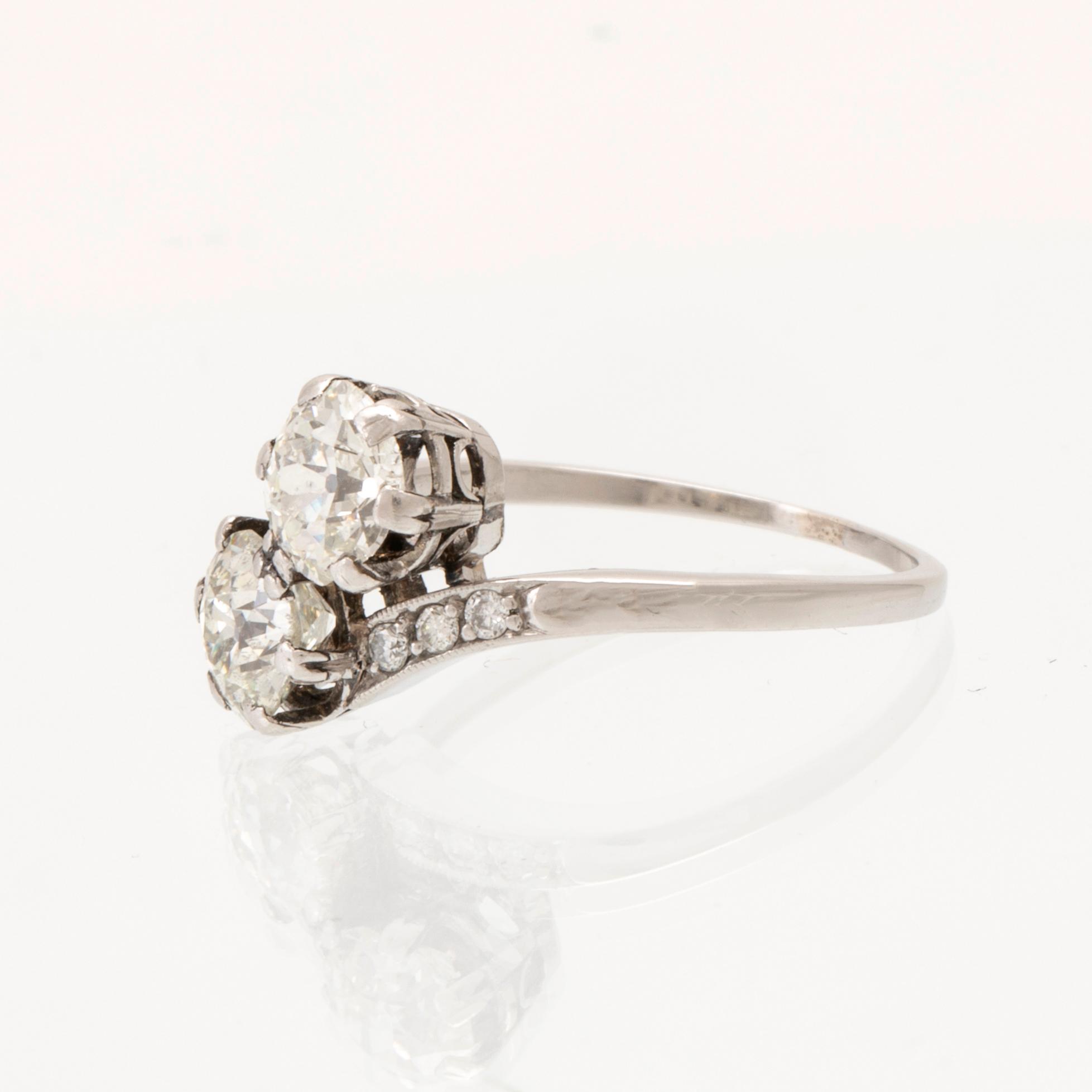 A platinum ring "sibling ring/twin ring" set with round old-cut and brilliant-cut diamonds.