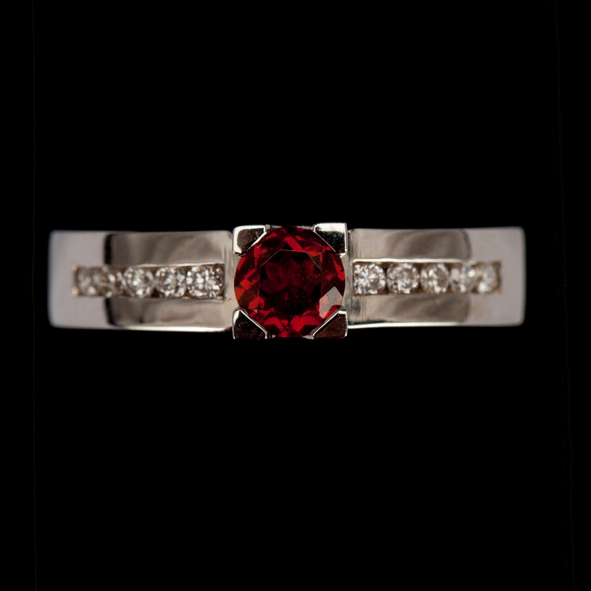 RING, vitguld 14K med granat 0,40 ct. och 10 st briljantslipade diamanter tot. 0,16 ct. Vikt 5 g.
