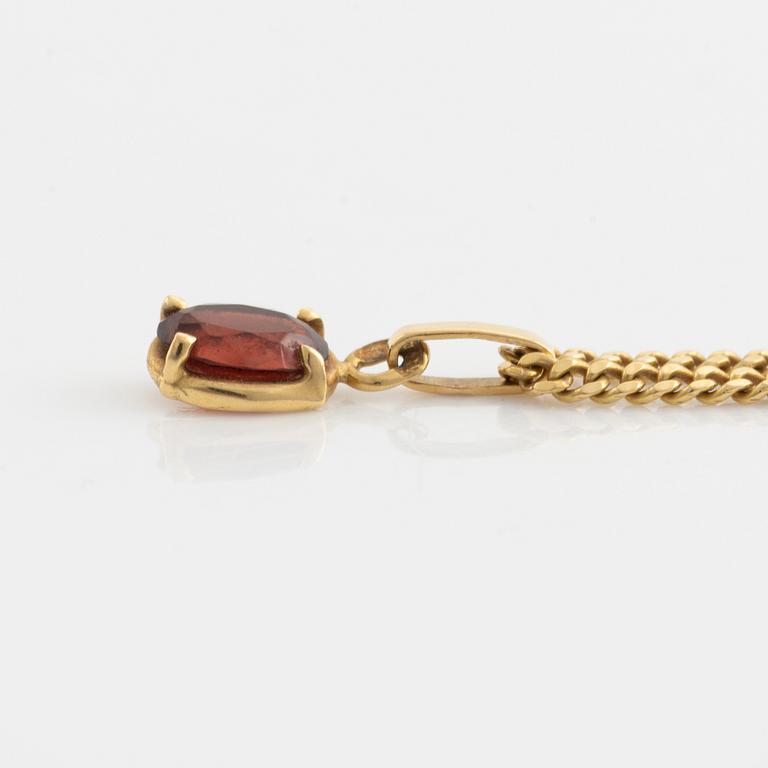 Pendant with chain with red stone, possibly garnet.