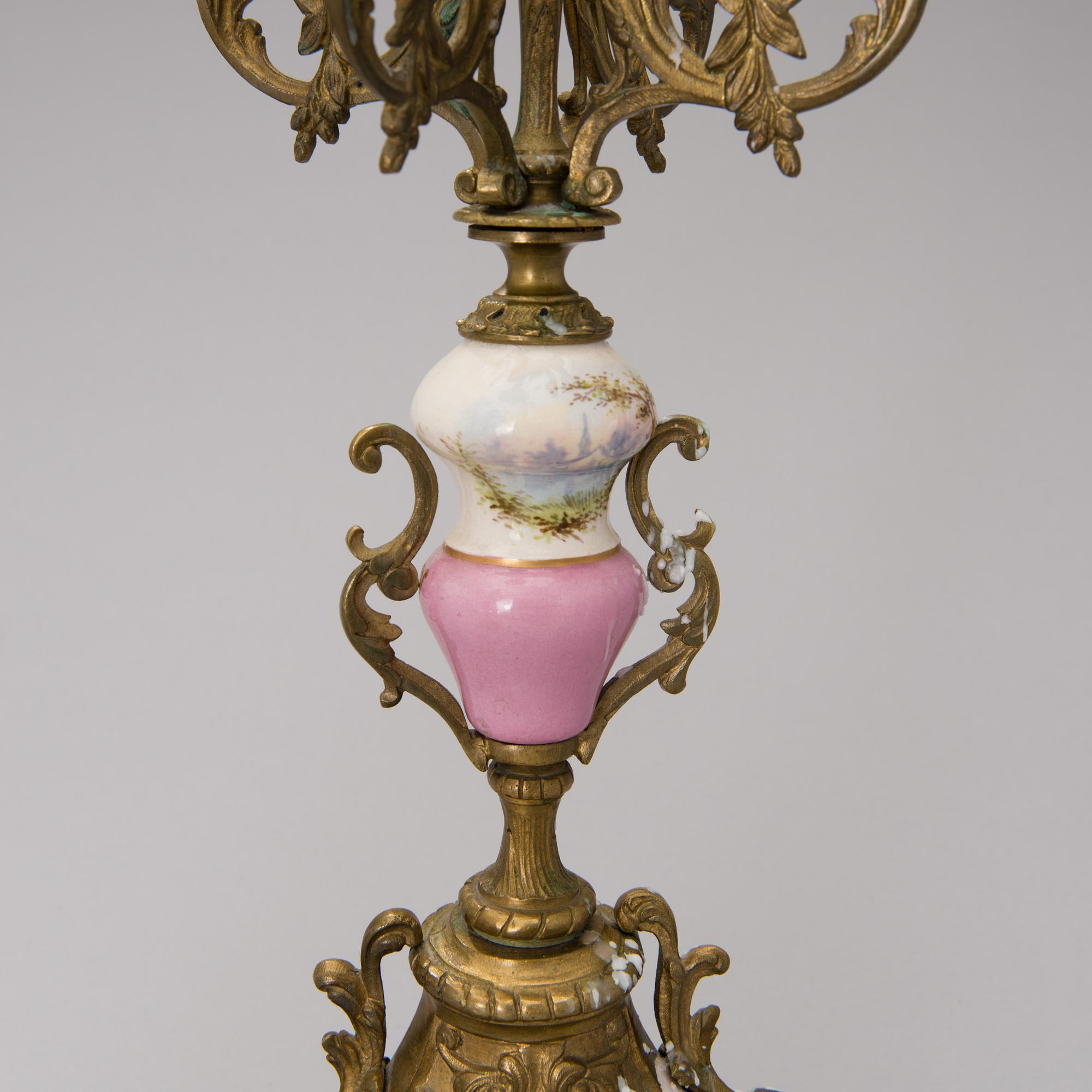A pair of gilt-bronze Rococo Revival candelabra with porcelain decors, from the latter half of the 19th century.